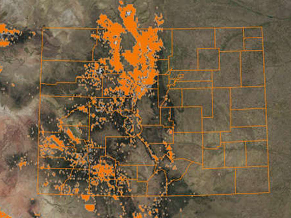 Aerial view of Colorado with the counties mapped out, with plots of bright orange centered around the mountains