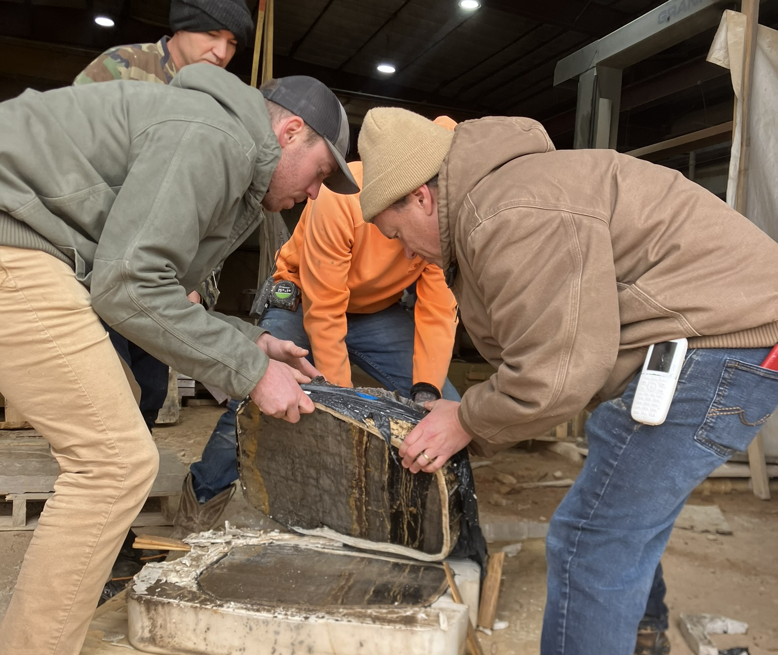 Museum Fossil Preparator Salvador Bastien and workers at Lyons Sandstone move a sliced rock slab that contains the history of one of Earth's most dramatic extinction events. (Photo/ Natalie Toth)