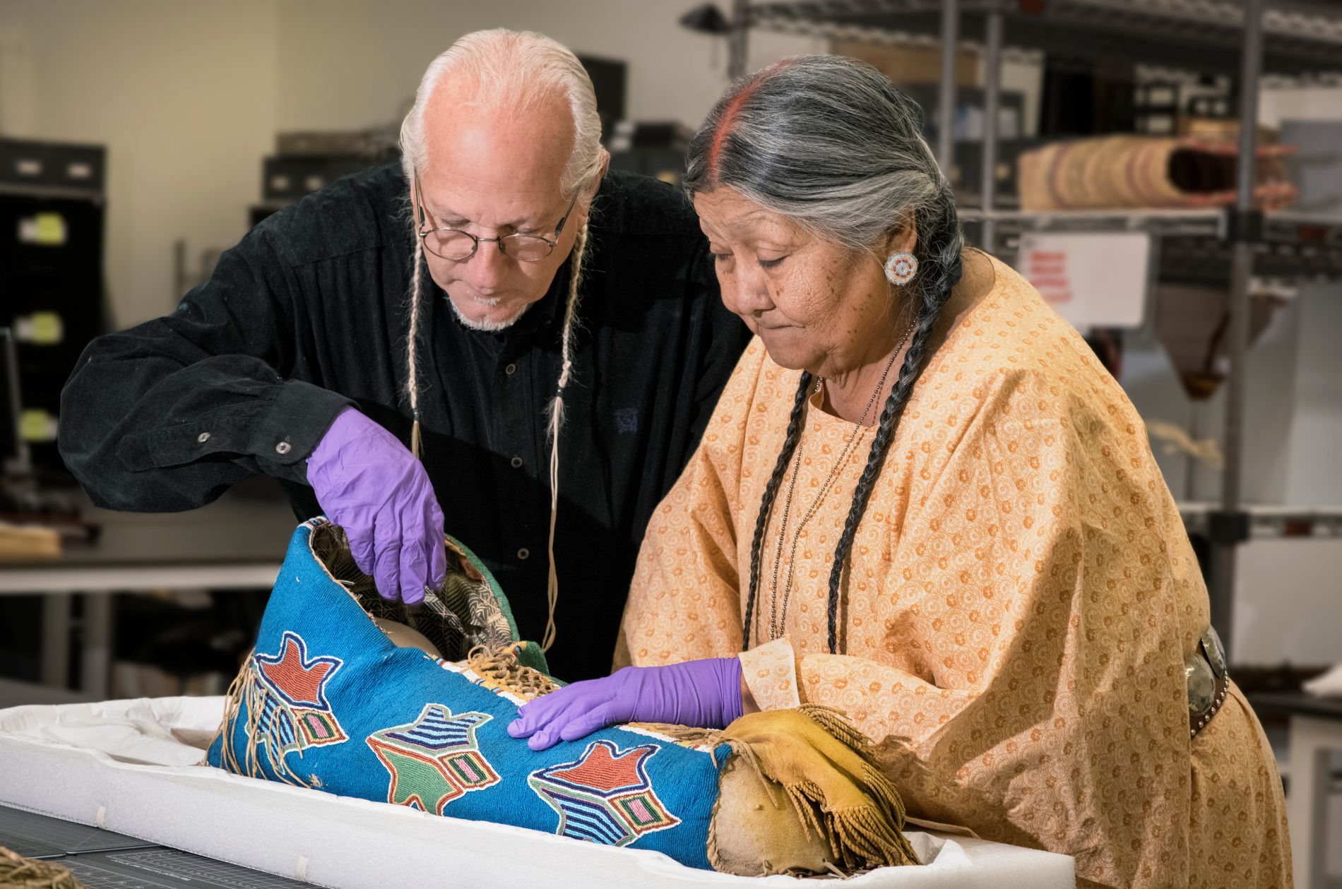 Examination of Denver Museum of Nature & Science beadwork material by Carl Jennings and Vanessa Paukeigope Jennings from the Kiowa tribe in Oklahoma. (Photo/ Rick Wicker)