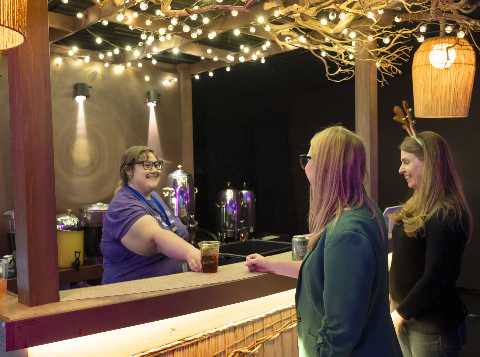 Adults guests at Magical Winter Nights grab a drink at the baobab-tree-themed bar in the transformed Third Floor Botswana diorama hall. (Photo/ Rick Wicker)