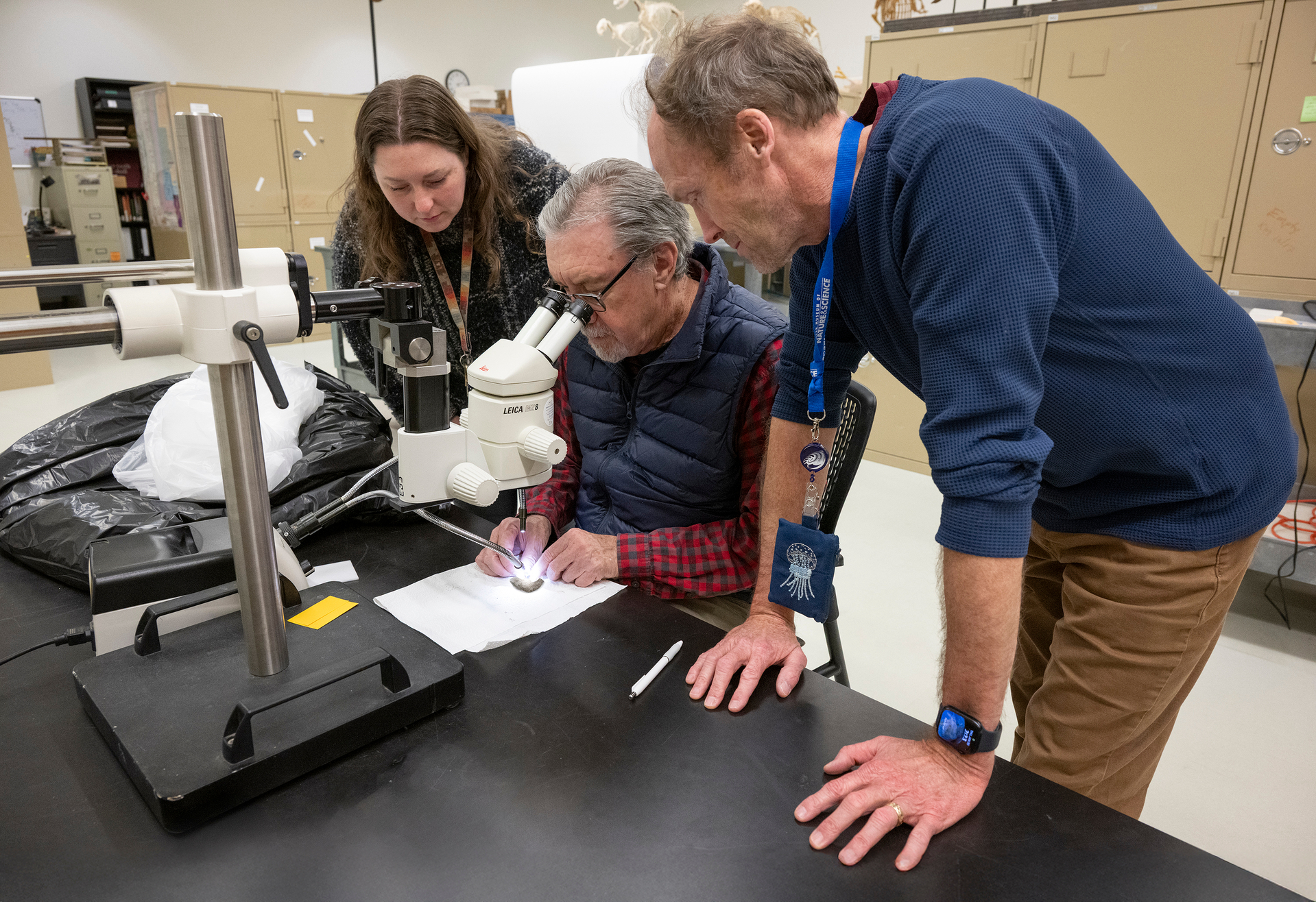 From left to right, report authors Dr. Gussie Maccracken, Dr. David Krause and Dr. Patrick O'Connor study the dinosaur fossil at the Denver Museum of Nature & Science.