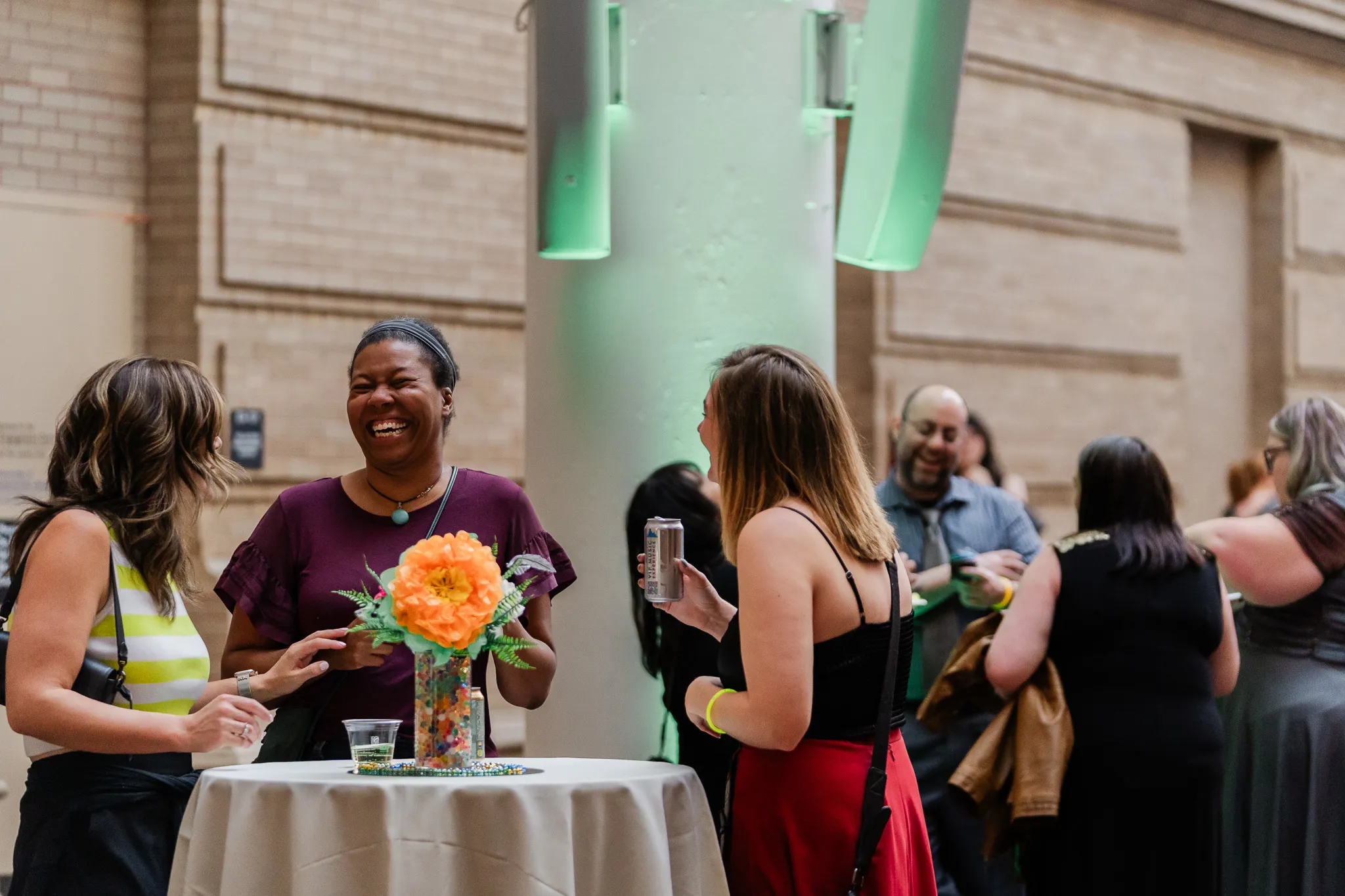 Group of adults around a table, laughing and talking at Denver Museum of Nature & Science. 