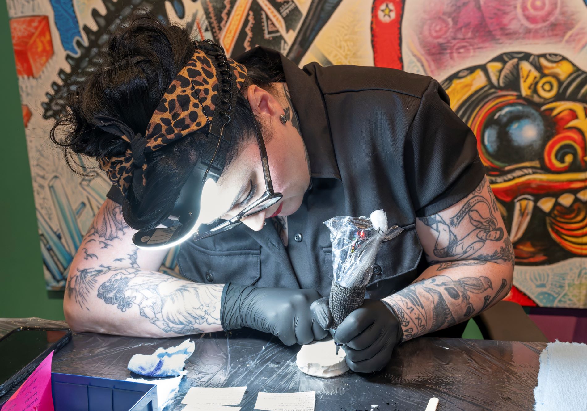 Artist Lora Bird of Nest Collective demonstrating for the public how tattoo technology can be used to label silicone molds on the Museum floor in May, 2024. (Photo/ Rick Wicker)
