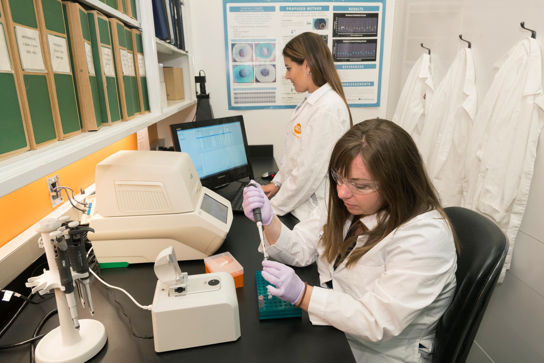 Tiffany and [insert name] conduct investigative work in the Genomic Lab. (Photo/ Rick Wicker)