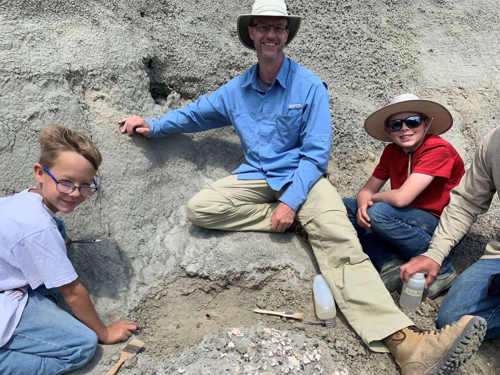 From left to right, Kaiden Madsen, Dr. Tyler Lyson and Jessin Fisher pose for photograph after discovering a fossil that belonged to a juvenile T. rex in the Hell Creek Badlands of North Dakota in July, 2023. (Photo/ Natalie Toth)