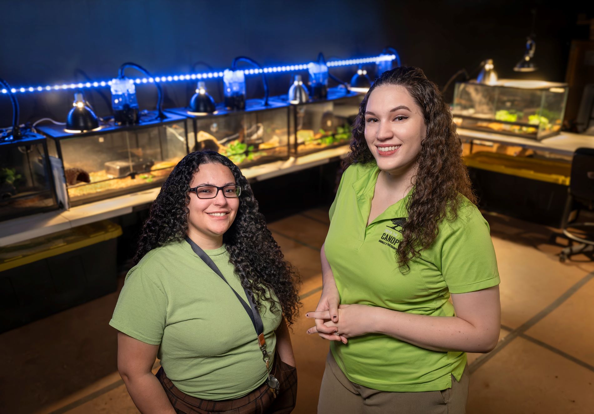 Wildlife Caretakers Donna Santiago and Jennifer Nicholas pose for a photo in the behind-the-scenes area in the "Animals of the Rainforest" temporary exhibition in the Denver Museum of Nature & Science. (Photo/ Rick Wicker)