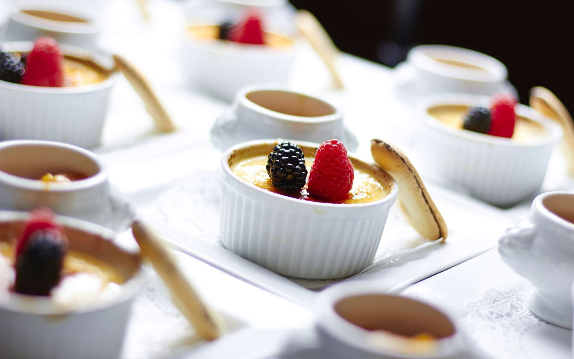 Desserts in white bowls in a row 