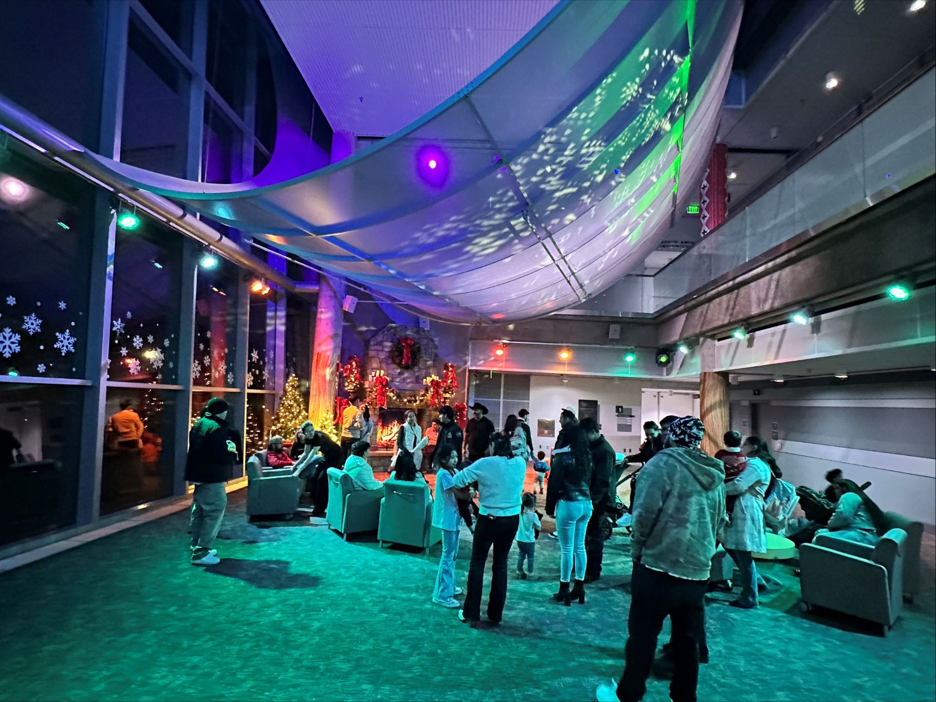 Guests gather by the fireplace under the beautiful holiday lighting in the Museum's transformed West Atrium. (Photo/ DMNS) 